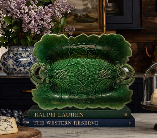 Decorative green ceramic platter on a book with 'Ralph Lauren' branding in a home setting.
