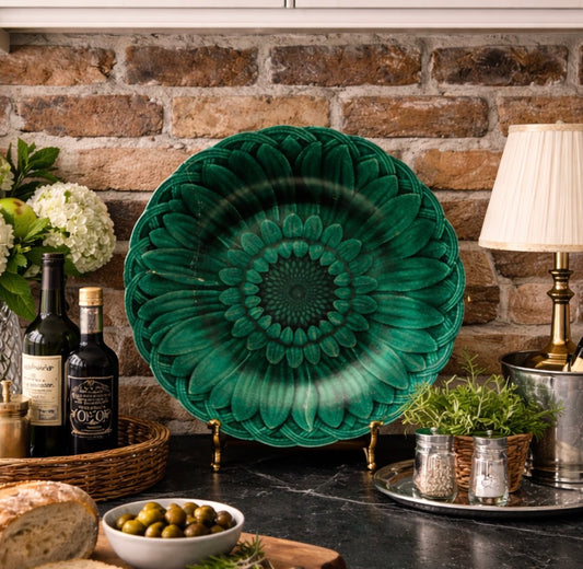 Decorative green plate on a kitchen counter with a stone wall background