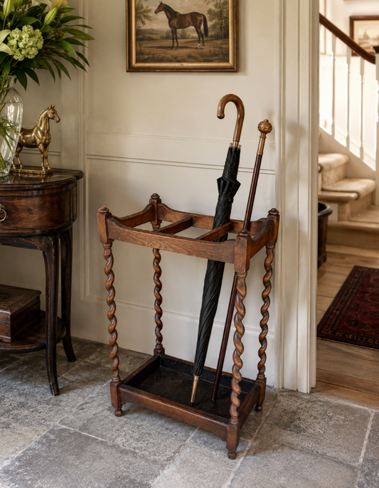 Wooden umbrella stand with umbrellas in a room with a staircase and decorative elements.