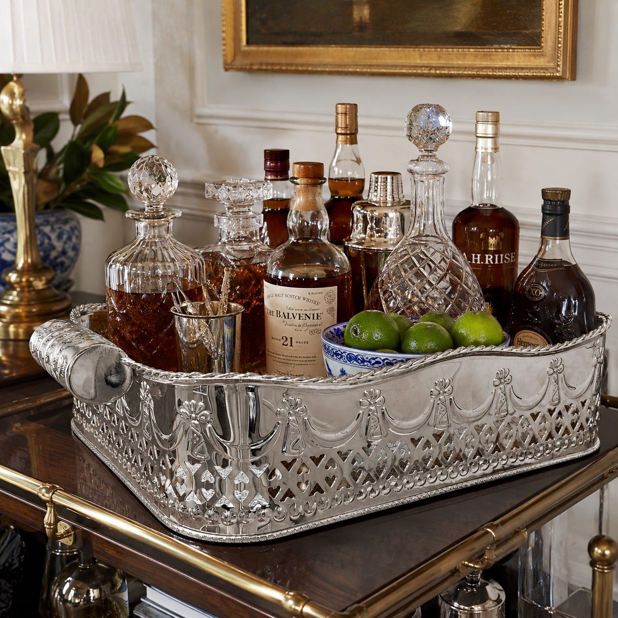Decorative tray with bottles of alcohol and limes on a bar cart.
