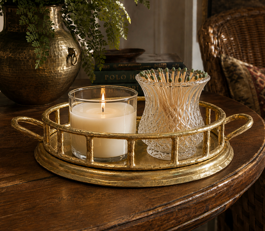 Decorative candle holder with a lit candle on a wooden surface