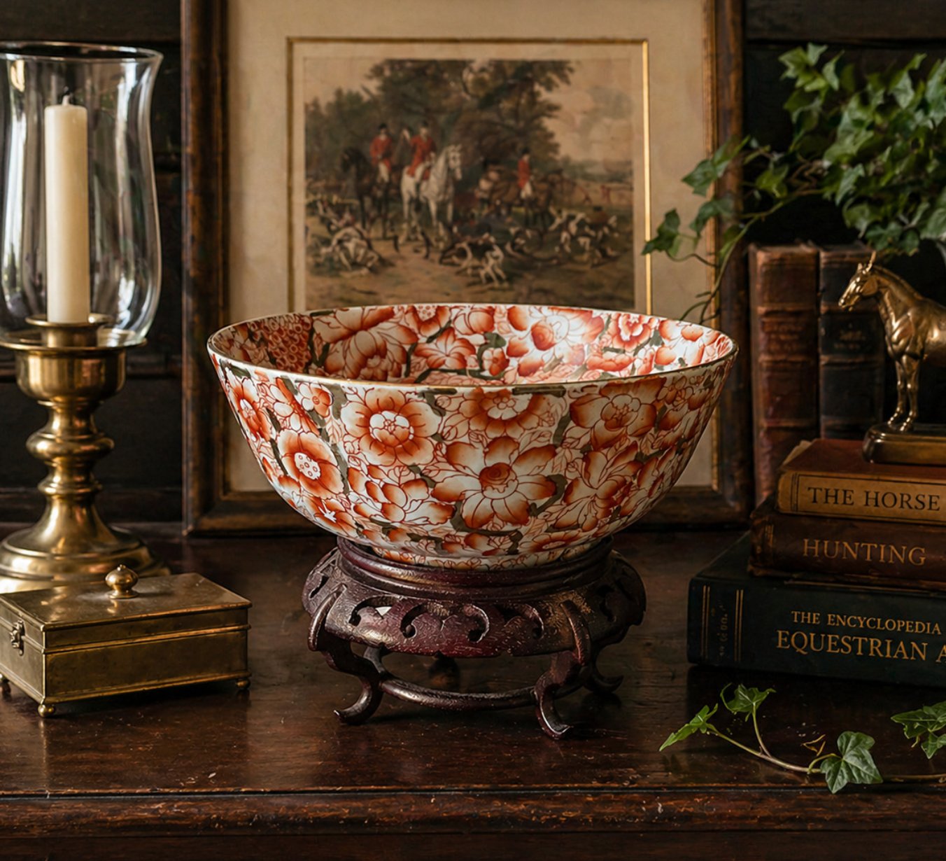 Decorative floral-patterned bowl on a wooden stand with books and a candle in the background