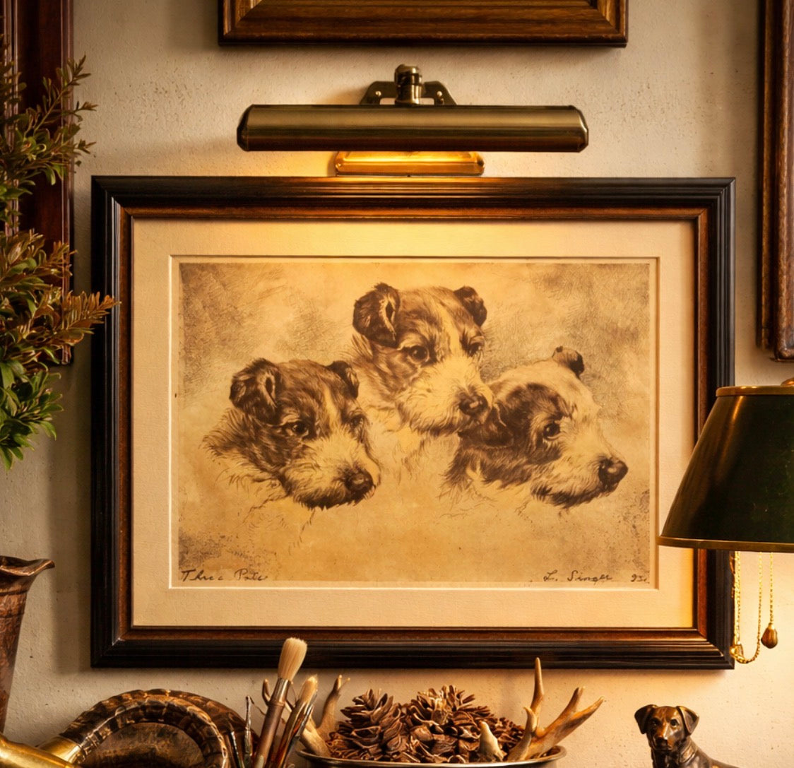Framed artwork of three dogs on a wall with decorative elements.