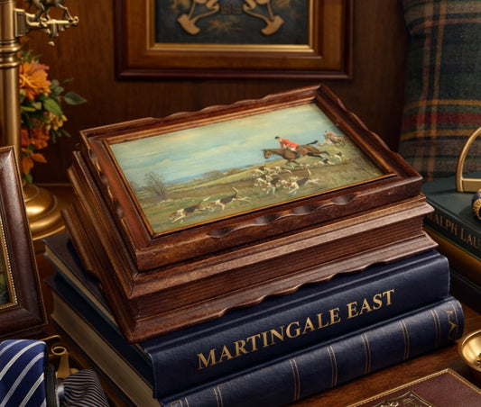 Wooden box with a painting on top of stacked books titled 'Martingale East' in an elegant interior setting.