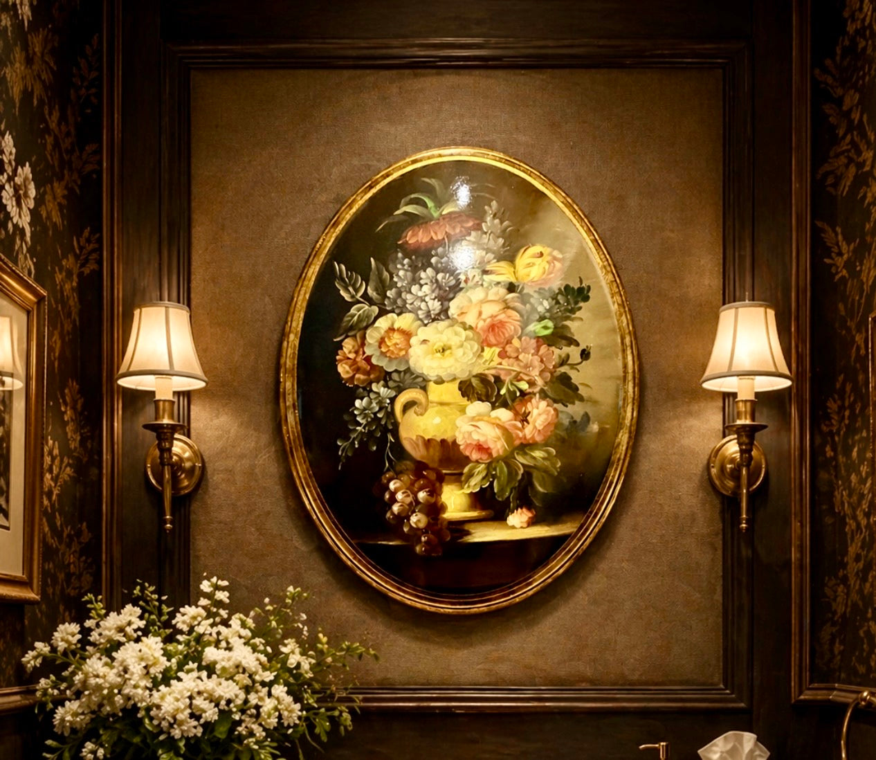 Decorative wall with floral painting, sconces, and flowers on a dark wall.