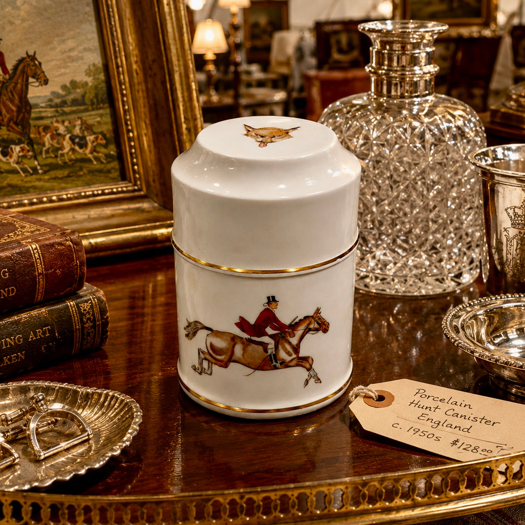 White canister with horse and rider design on a wooden table with decorative items.