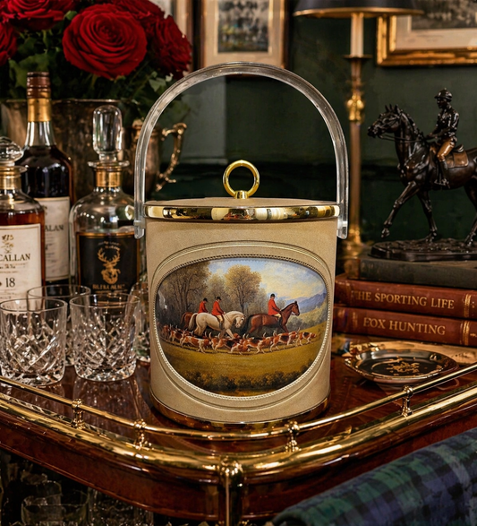 Decorative ice bucket with hunting scene on a table with alcohol bottles and glasses.