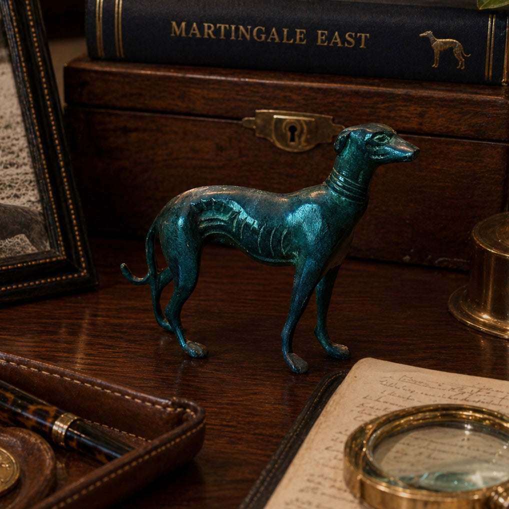 Bronze dog figurine on a wooden surface with books and a magnifying glass in the background.