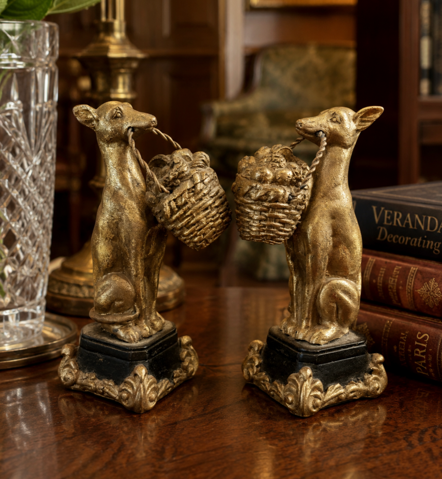 A pair of decorative bookends shaped like seated dogs carrying woven baskets, displayed on a wooden table in a styled interior setting.