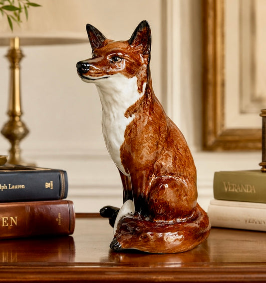 Fox figurine on a wooden surface with books in the background