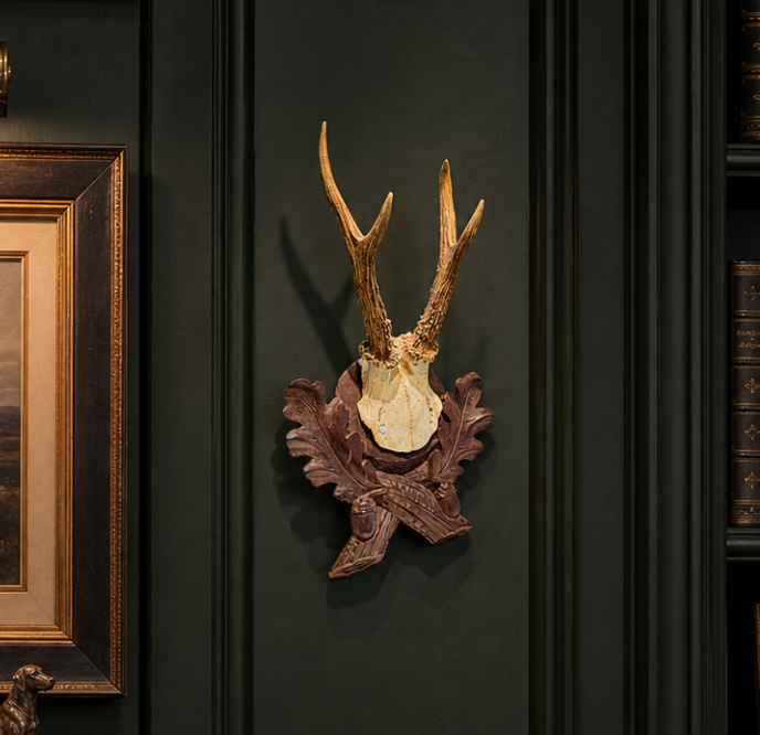 Decorative wall mount with deer antlers on a dark wall