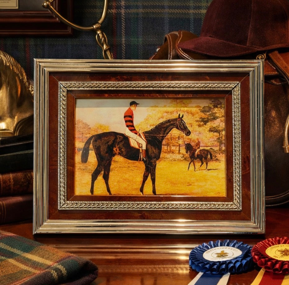 Framed painting of a jockey on a horse with a plaid background