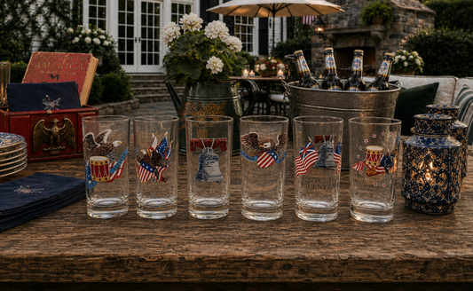 Set of glasses with American flag design on a wooden table outdoors.